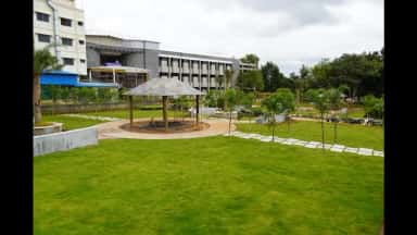 Landscaped lawn and gazebo in front of the Siddaganga Medical College building