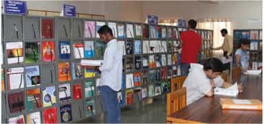 Students browsing journal display racks in the central library of Smt. Kashibai Navale Medical College