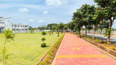Landscaped central walkway with the white college buildings of SR Patil Medical College, Badagandi