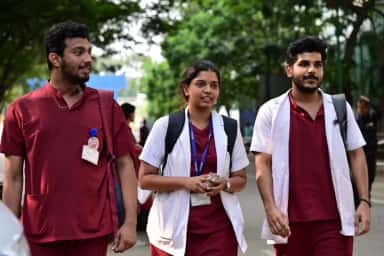 Medical students of Sri Devaraj Urs Medical College walking on the tree-lined campus road at Tamaka