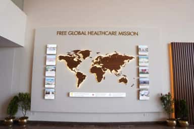 Free Global Healthcare Mission display wall in the SMSIMSR lobby mapping the trust's free hospitals