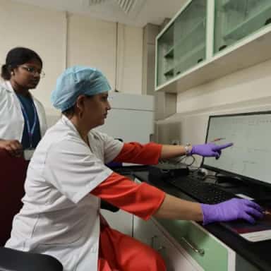 Faculty and a student reviewing analyser output in a research and diagnostic laboratory at Sri Ramachandra Medical College, Chennai