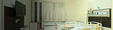 Private inpatient room with hospital bed and patient monitoring panel at SRM Medical College Hospital