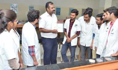 Faculty member demonstrating to a group of students in the microbiology laboratory at SSIMS & RC Davangere