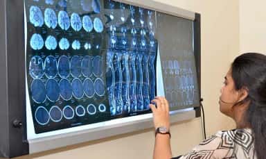 Radiology resident reading MRI films on a viewing panel at the SSIMS & RC teaching hospital, Davangere