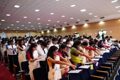 MBBS students standing to take an oath during an induction ceremony in the SVS Medical College auditorium