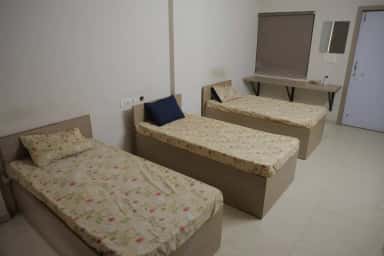 Furnished on-campus hostel room with single beds at Swaminarayan Institute of Medical Sciences & Research, Kalol