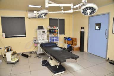 Operating theatre with surgical lights and anaesthesia machine at PSM Hospital, Saij, Kalol