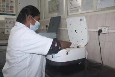 Laboratory technician operating a centrifuge in the pathology laboratory at Tagore Medical College and Hospital