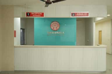 Reception desk with the Takshashila Medical College Hospital logo and Tamil 'Reception' and 'ABHA ID' counter signs