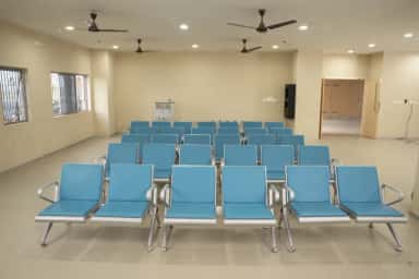 Patient waiting hall with rows of blue chairs at Takshashila Medical College Hospital
