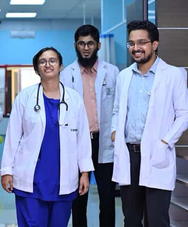 Doctors in white coats in a corridor of the teaching hospital at Yenepoya Medical College, Mangalore