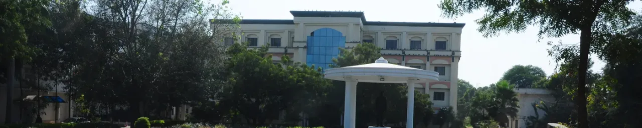 Bhaskar General Hospital building behind trees with white gazebo in front, Yenkapally campus, Moinabad