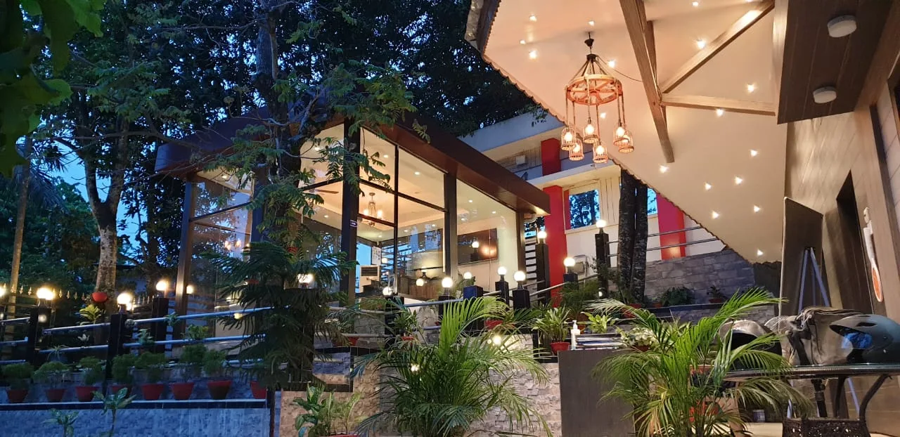 The glass-fronted entrance to JBS, lit warmly at dusk — Jettwings Business School