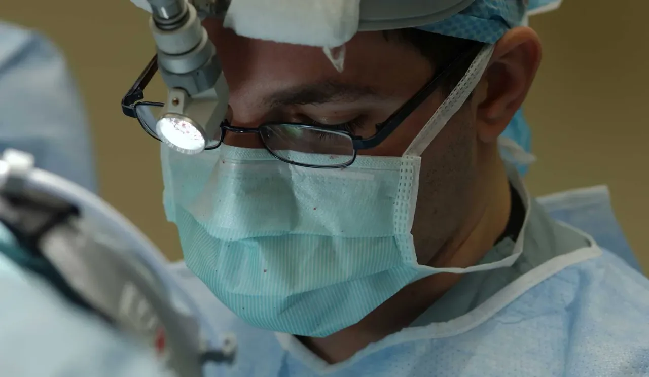 Surgeon operating with a microscope in an operation theatre at Adichunchanagiri Hospital