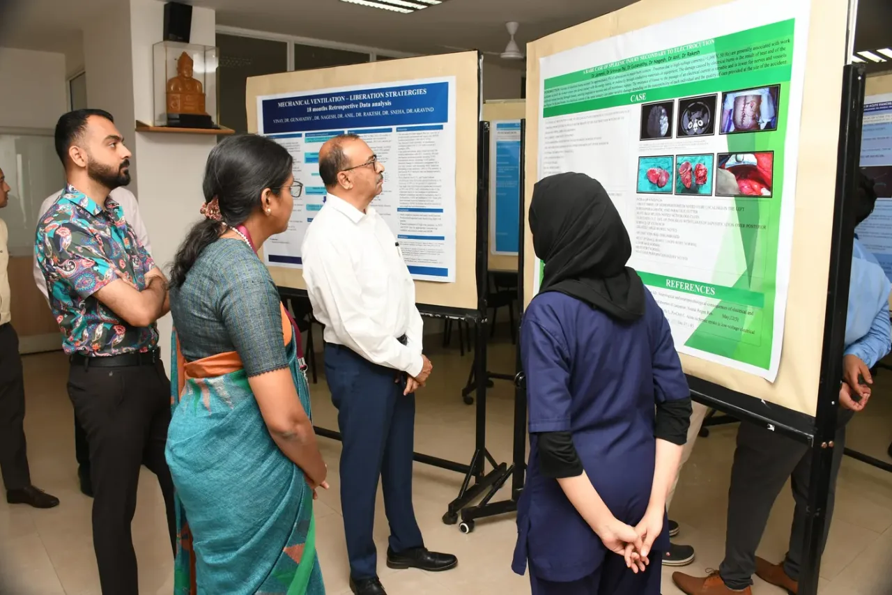 Faculty and residents reviewing scientific posters at SDM College of Medical Sciences and Hospital, Dharwad