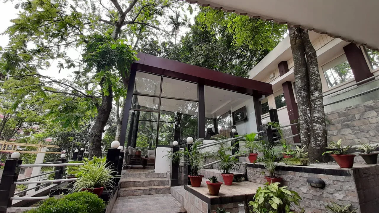 Glass-fronted foyer set among mature trees on the hillside — Jettwings Business School