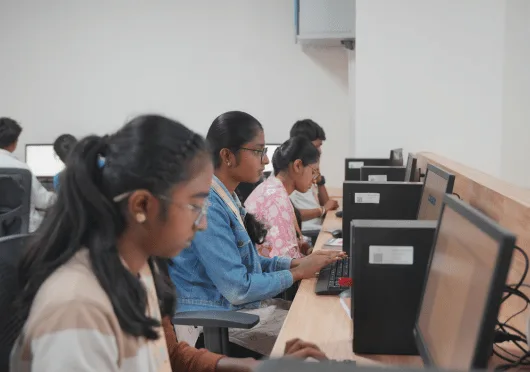 Student discussing in computer lab at VYMAK Degree College