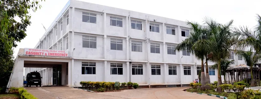 Casualty and Emergency block of Sambhram Hospital, KGF, with an ambulance at the porch (archived college photo, 2024)