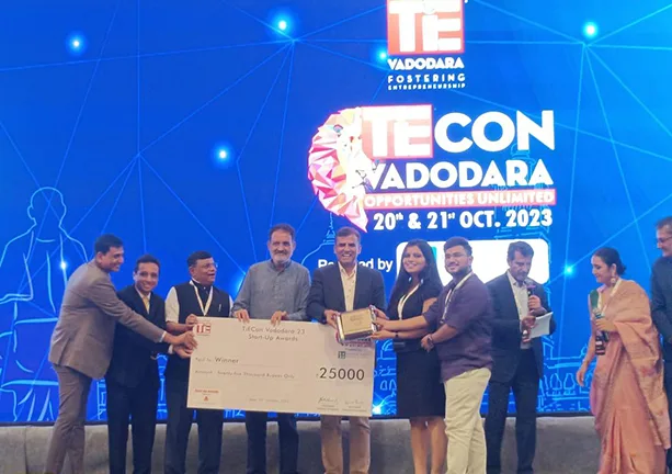 Students receiving cheque and award at TiEcon Vadodara Event — Navrachana University