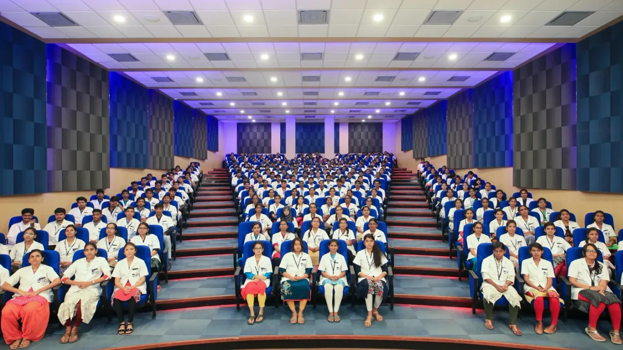 Navodaya Medical College auditorium filled with medical students in white coats
