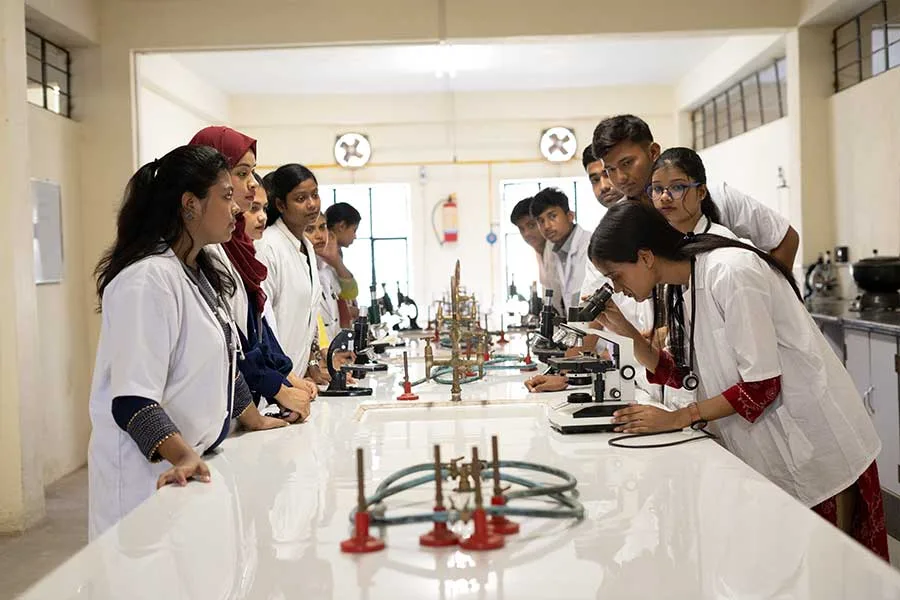 students-in-white-lab-coats-conducting-experiments-in-college-laboratory — Sahajpath College of Pharmacy