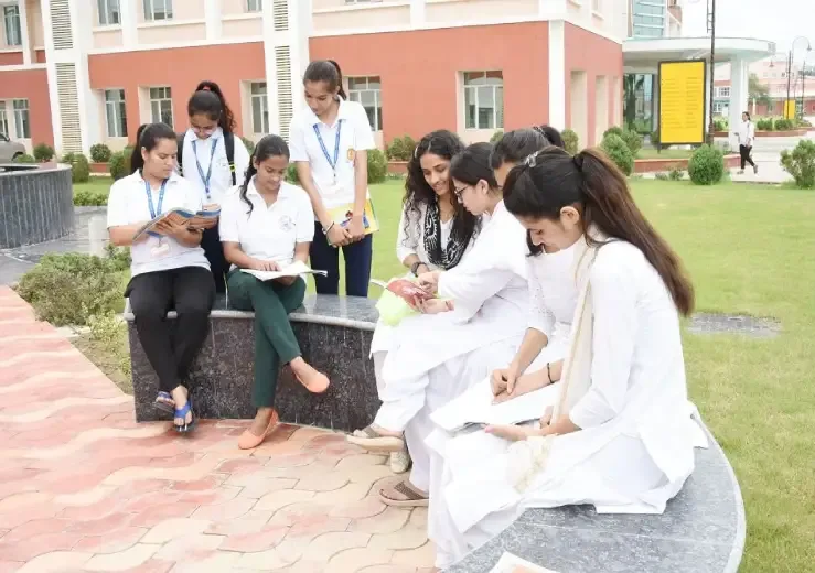 Students studying together on the University of Patanjali campus lawn outside the academic building