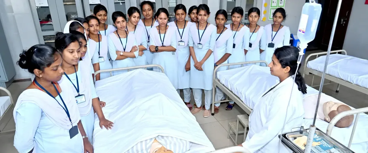 Nursing students receiving practical bedside instruction — R.N.S. College of Nursing
