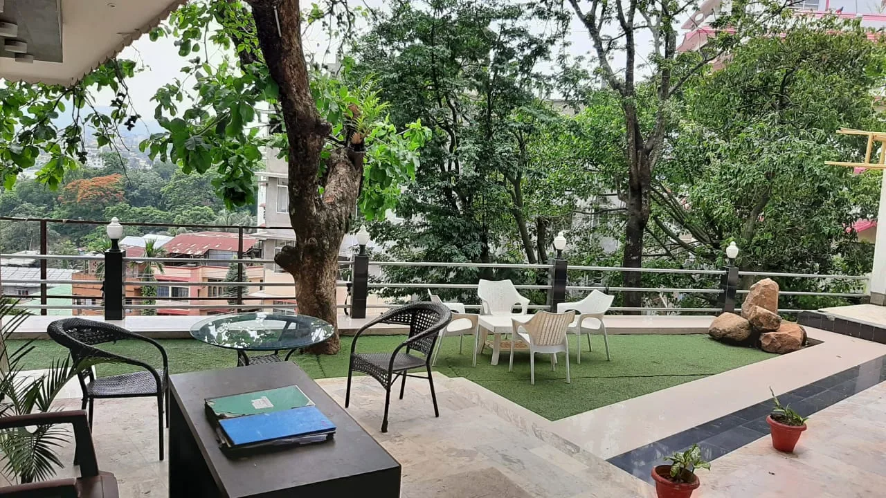 Outdoor lounge with chairs set around old trees, overlooking the hillside — Jettwings Business School