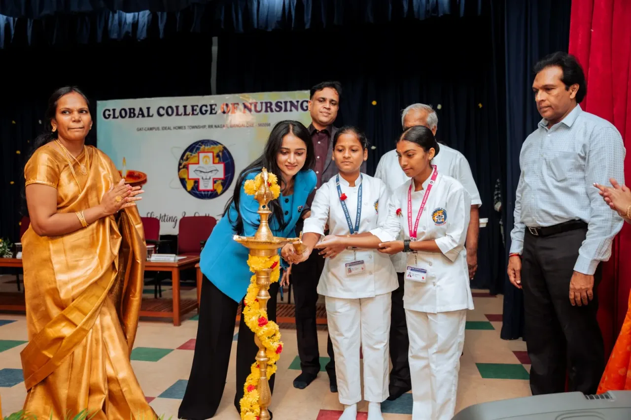 Lamp-lighting ceremony with students and faculty on stage — Global College of Nursing