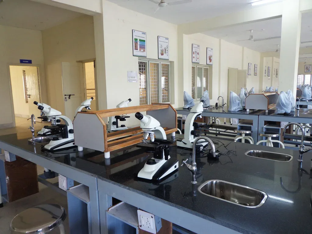 Laboratory benches lined with binocular microscopes at Kamineni Academy of Medical Sciences, Hyderabad