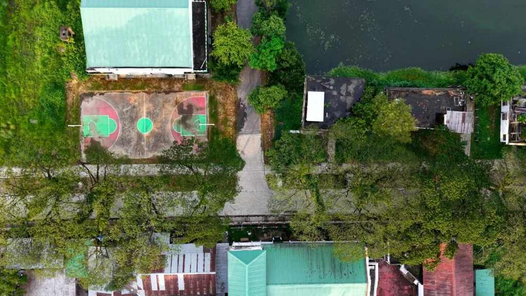 Aerial view of outdoor basketball courts beside the campus gymnasium and pond — gauhati-university-guwahati