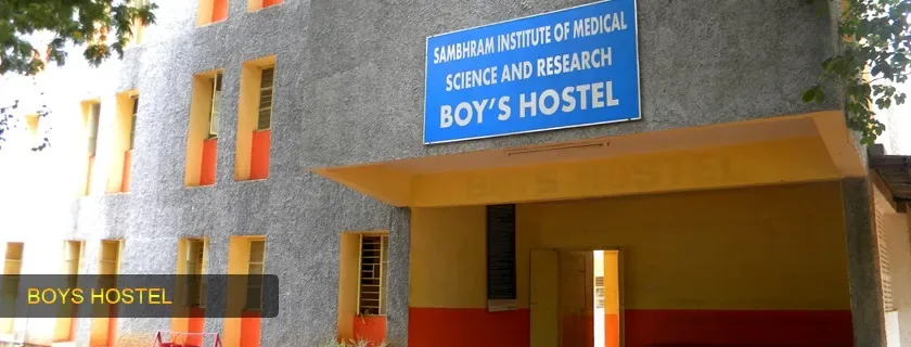 Boys' hostel of Sambhram Institute of Medical Science and Research, KGF, with its name board over the entrance (archived college photo, 2024)