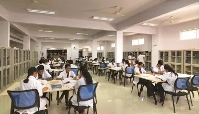 Students in white coats studying in the library reading room at Sapthagiri Institute of Medical Sciences, Bengaluru
