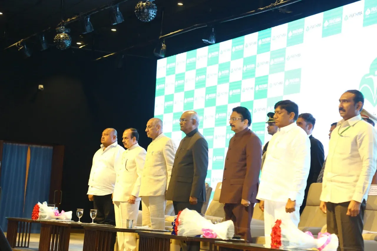 Dignitaries standing on stage at the Prathima Institute of Medical Sciences auditorium during the Presidential visit on 22 December 2018