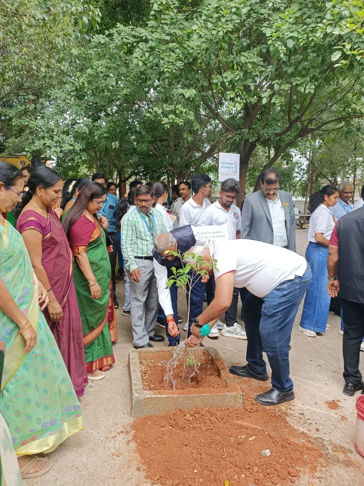 Students and faculty participating in a campus tree-planting event — Global College of Nursing