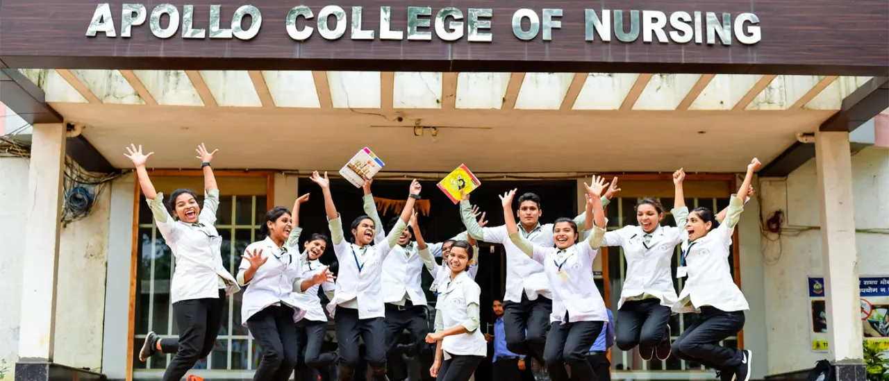 Students gathered outside the signed Apollo College of Nursing entrance