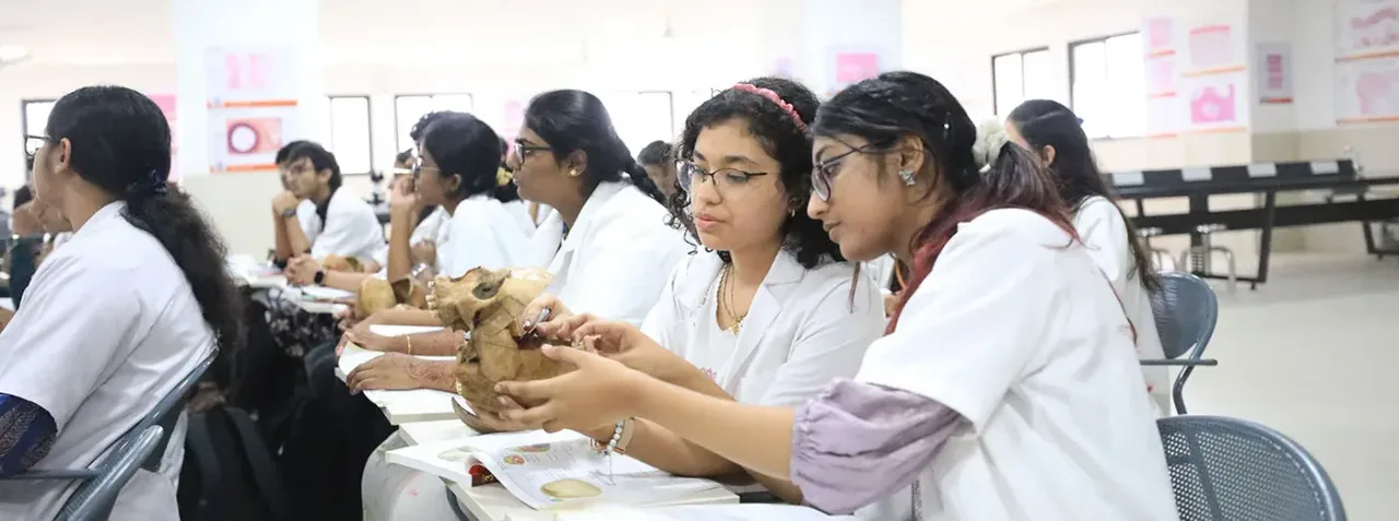 Students studying a skull specimen in the anatomy room at PESUIMSR