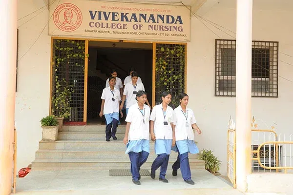 College entrance with students and institutional signage — Vivekananda School & College of Nursing
