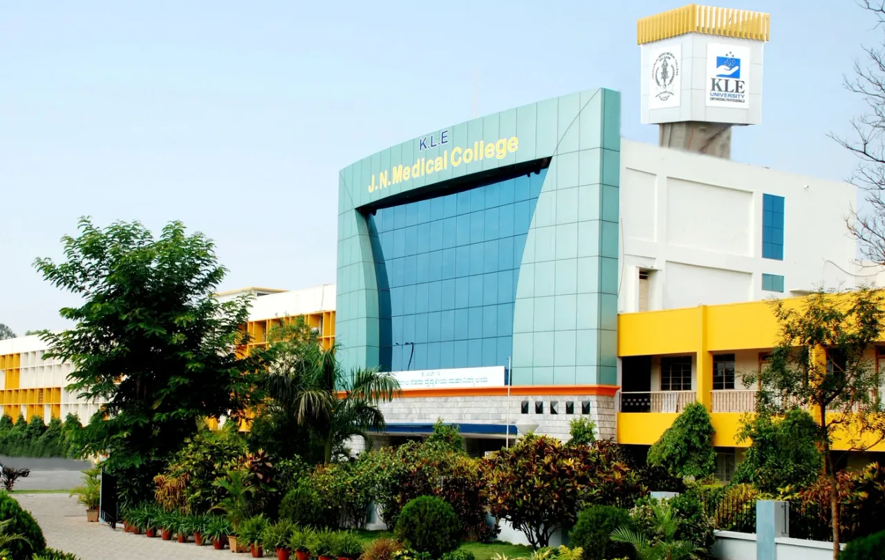 Main building of KLE Jawaharlal Nehru Medical College in Belagavi with the college name on its glass facade and the KLE tower behind