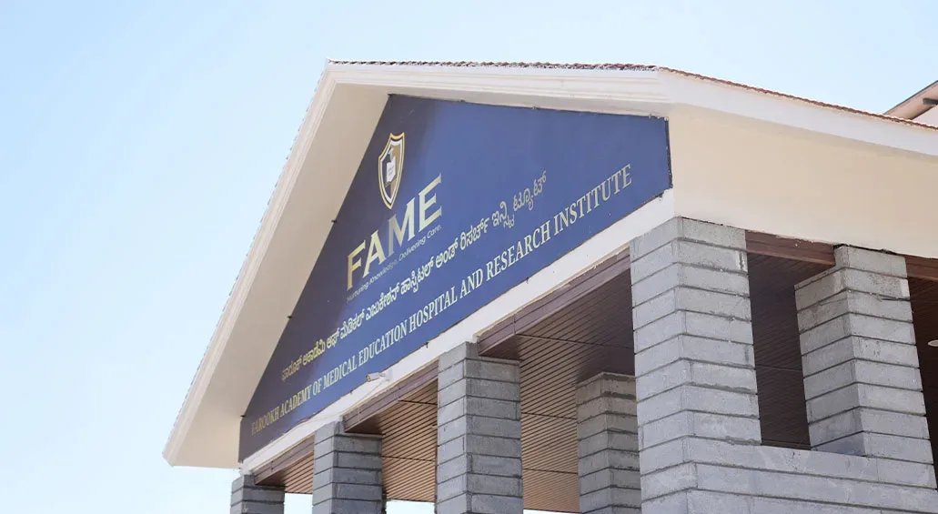 FAME building gable with the institute's name signage against the sky, Mysore