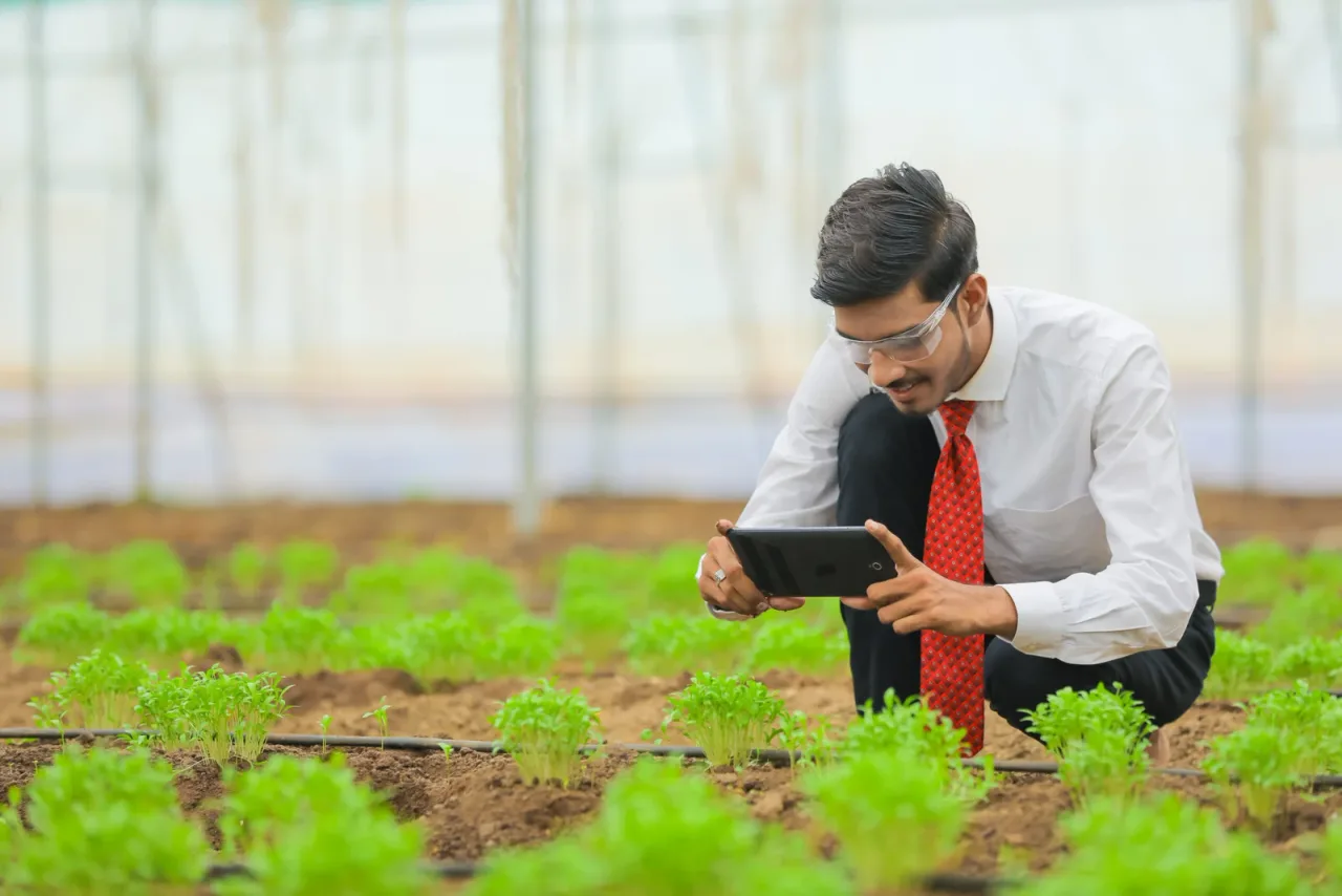 Technology and people concept, Young indian agronomist using tablet or smartphone at greenhouse — Subhash Chandra Bose Institute of Higher Education