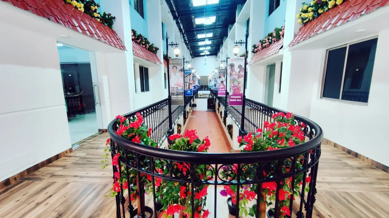 Bright college corridor with railings, planters and Saveetha College of Nursing banners
