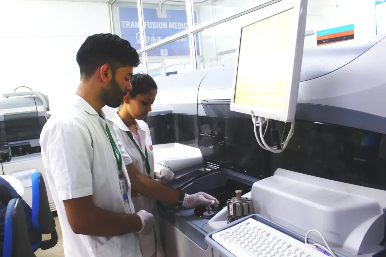 Staff operating medical testing equipment in the transfusion medicine laboratory — Saveetha College of Nursing