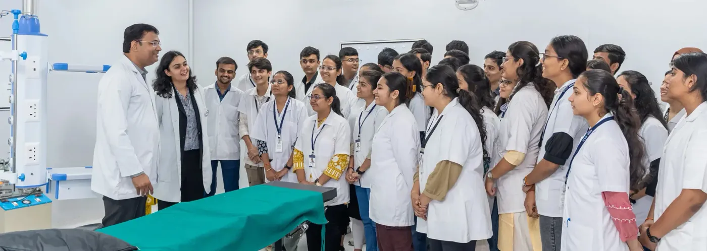Faculty member demonstrating to MBBS students around a teaching table at Ananya College of Medicine & Research, Kalol