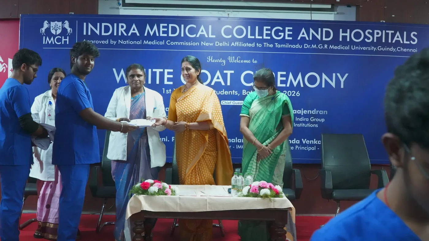 Indira Medical College & Hospitals White Coat Ceremony on a branded stage marking an MBBS cohort, Thiruvallur