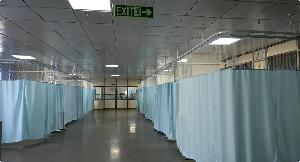 Curtained inpatient beds in a ward at the General Hospital, Shantabaa Medical College, Amreli