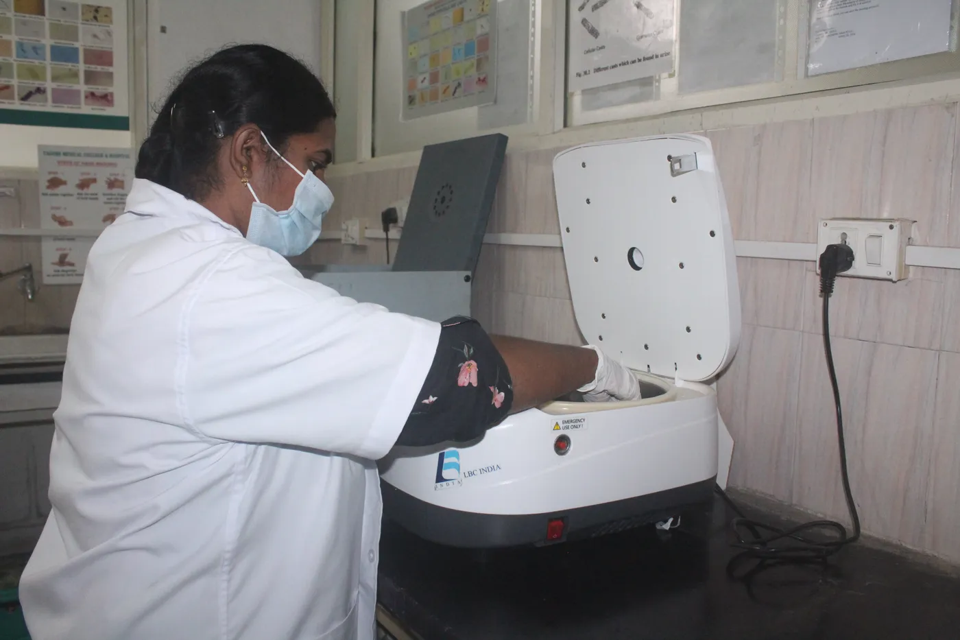 Laboratory technician operating a centrifuge in the pathology laboratory at Tagore Medical College and Hospital