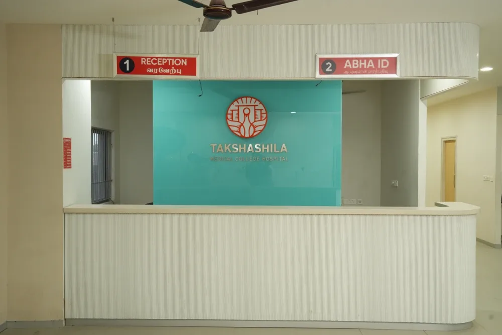 Reception desk with the Takshashila Medical College Hospital logo and Tamil 'Reception' and 'ABHA ID' counter signs