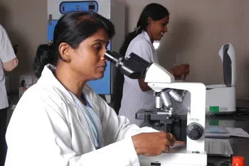 Students at microscopes in the microbiology laboratory, The Oxford Medical College